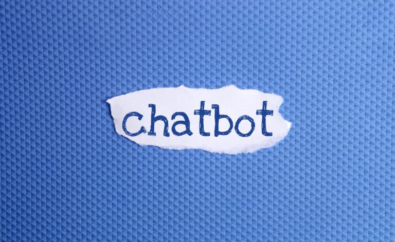 A torn piece of white paper with the word chatbot written in blue letters is placed on a textured blue background, evoking creativity and innovation—key elements in building an Irish brand.