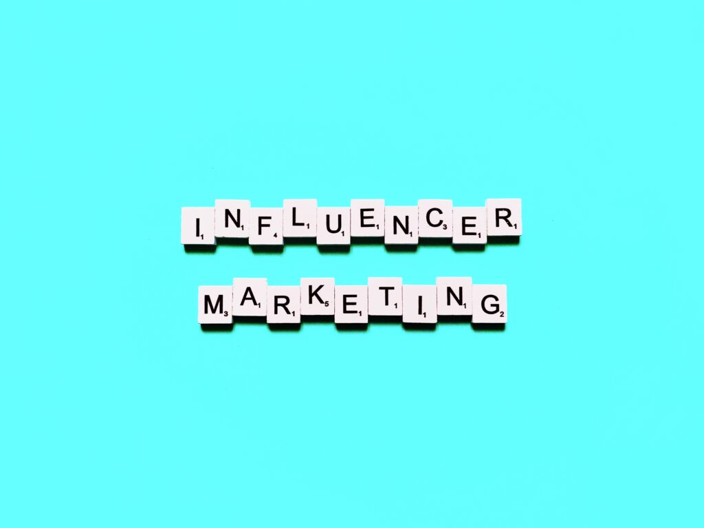 Letter tiles spelling INFLUENCER MARKETING are arranged in two rows on a bright turquoise background, capturing the creativity and strategy behind building an Irish brand.