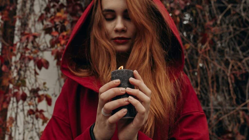 a woman in a red hoodie holding a lighter
