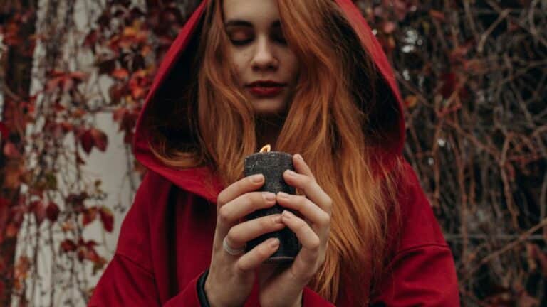 a woman in a red hoodie holding a lighter