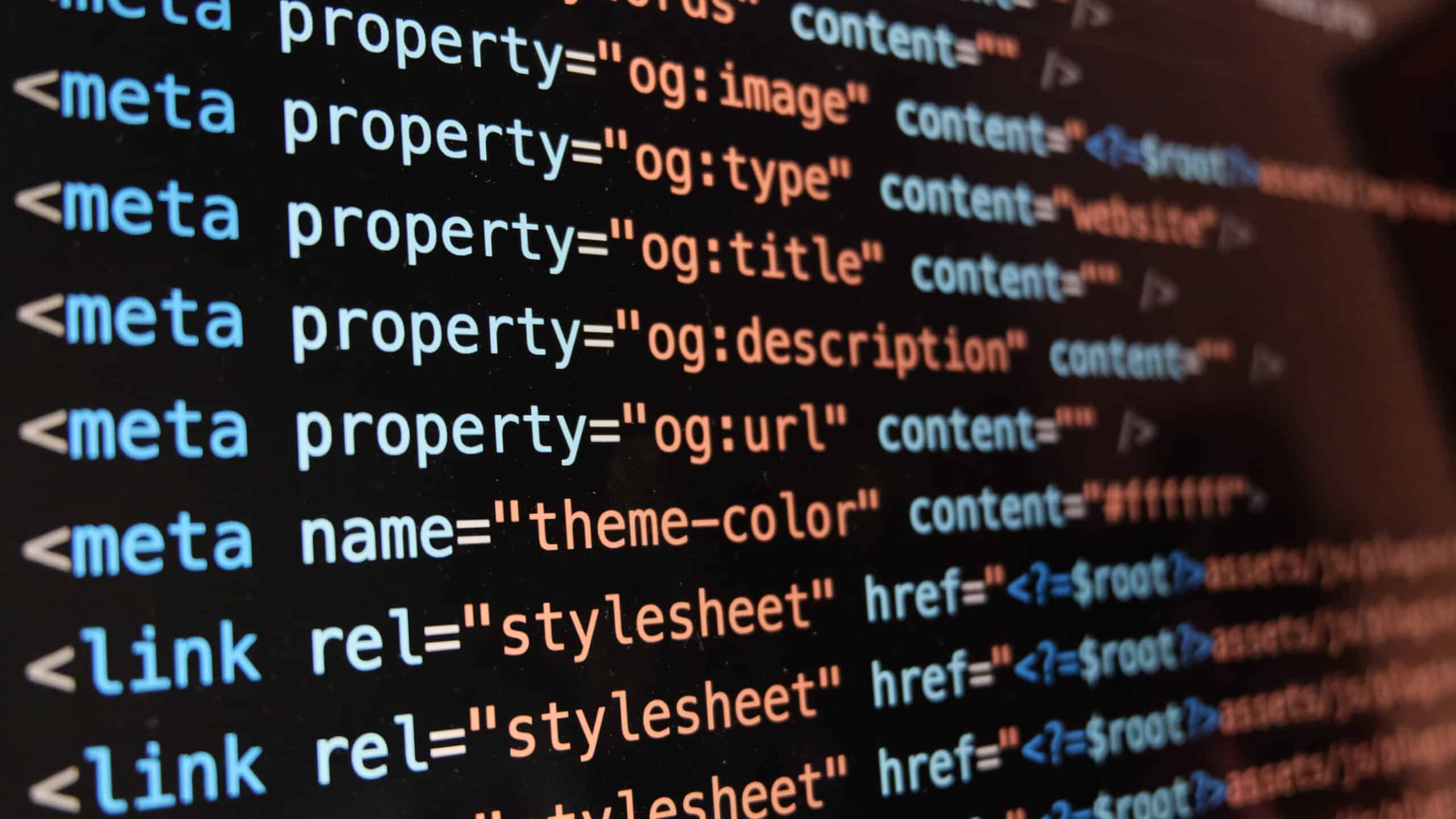 Close-up of a computer screen displaying HTML meta tags and link elements in code—key steps when building an Irish brand online—with properties for image, title, description, URL, theme color, and stylesheet references.