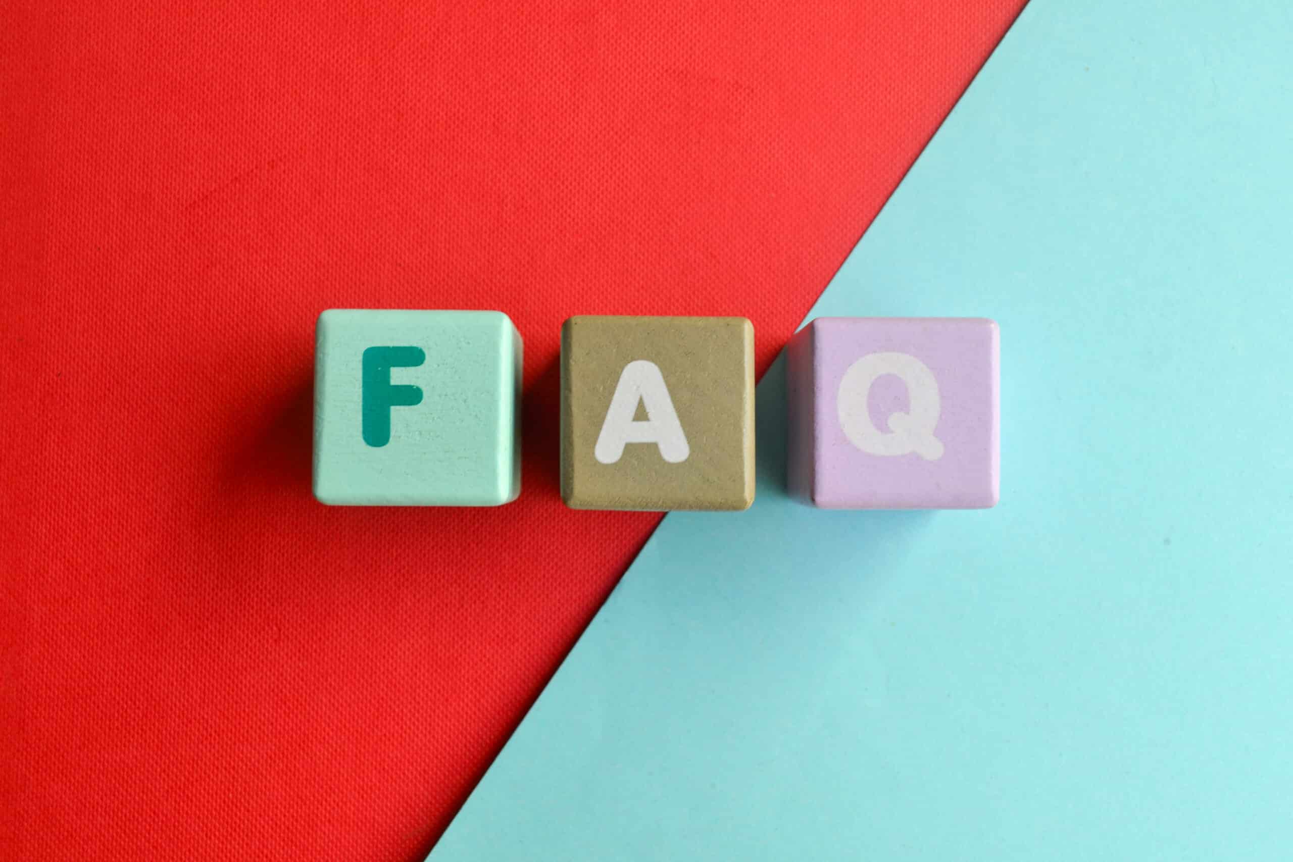 Three colored blocks with the letters F, A, and Q are arranged side by side on a background split diagonally between red and light blue, reflecting the playful creativity often seen when building an Irish brand.