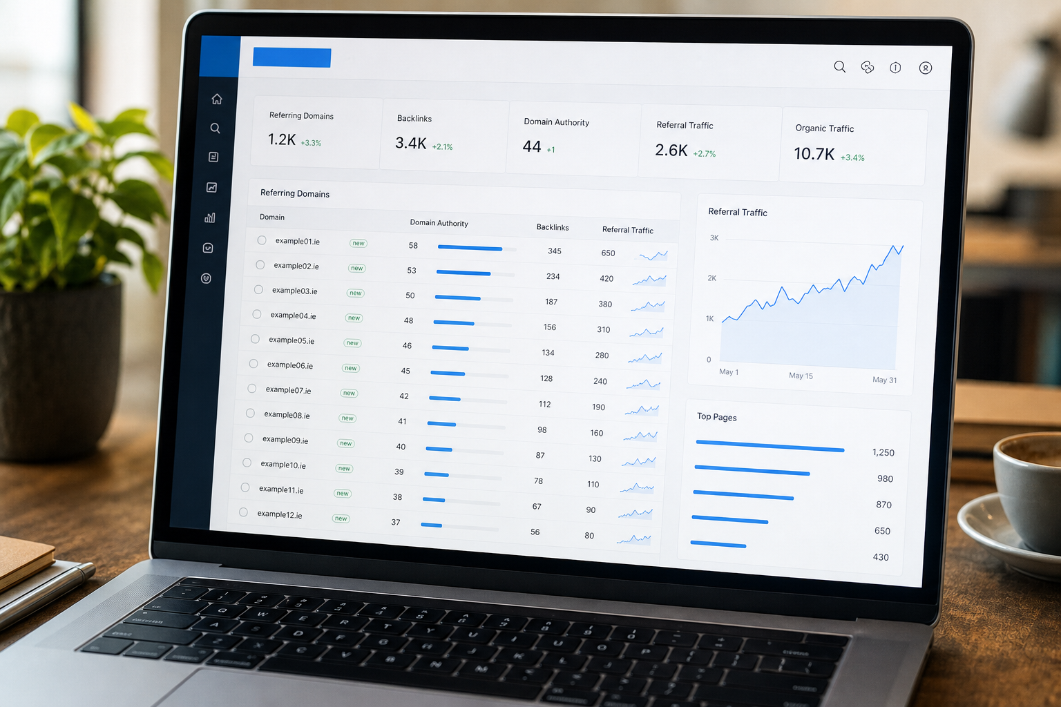 Laptop screen displaying a digital analytics dashboard with metrics like backlinks, referral and organic traffic, graphs, tables of referring domains, top pages list, and data visualizations.