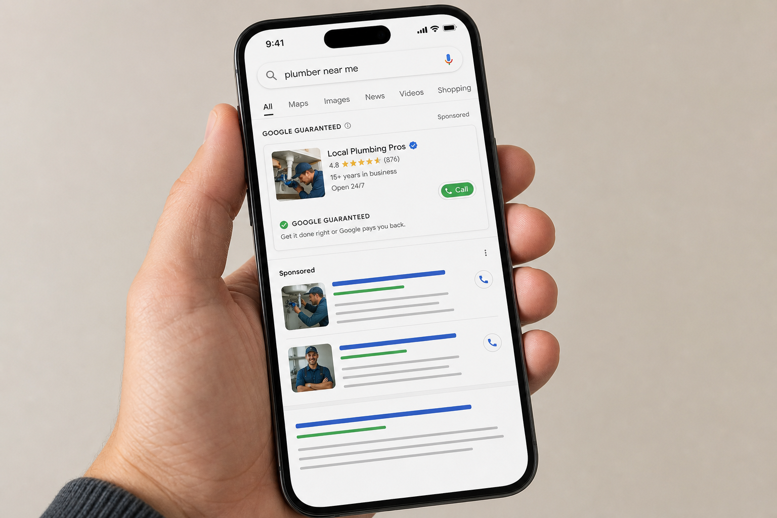 A hand holds a smartphone displaying Google search results for plumber near me, showing local plumbing business ads, ratings, contact info, and call buttons.
