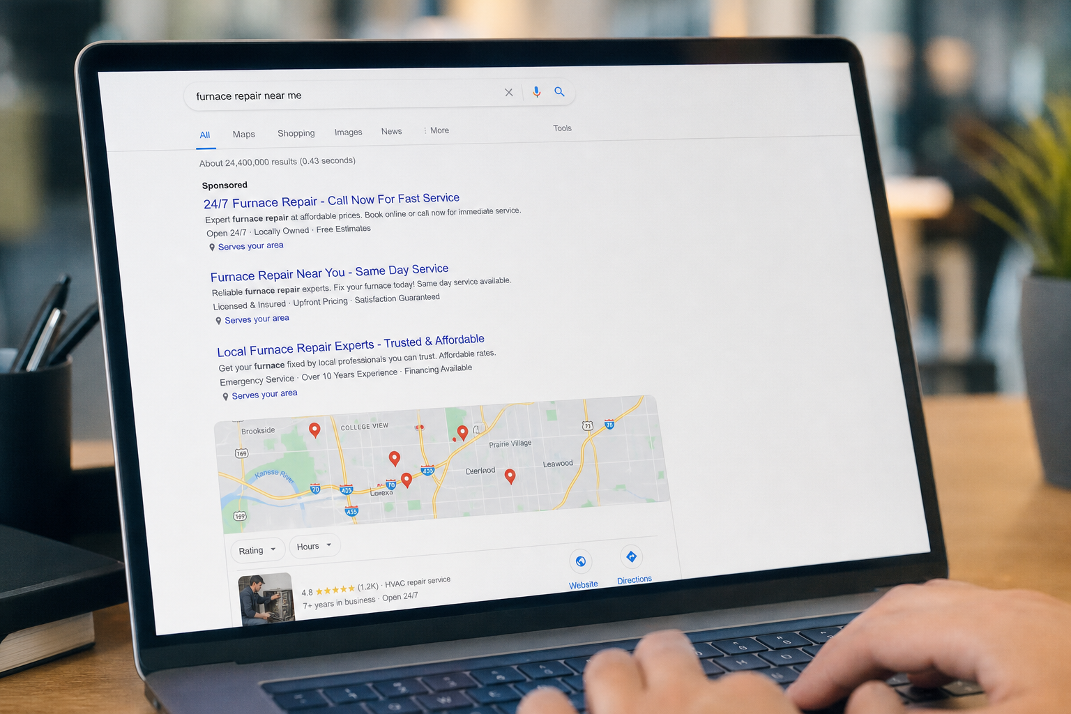 A laptop screen displaying Google search results for furnace repair near me, featuring sponsored listings and a local map with service locations.